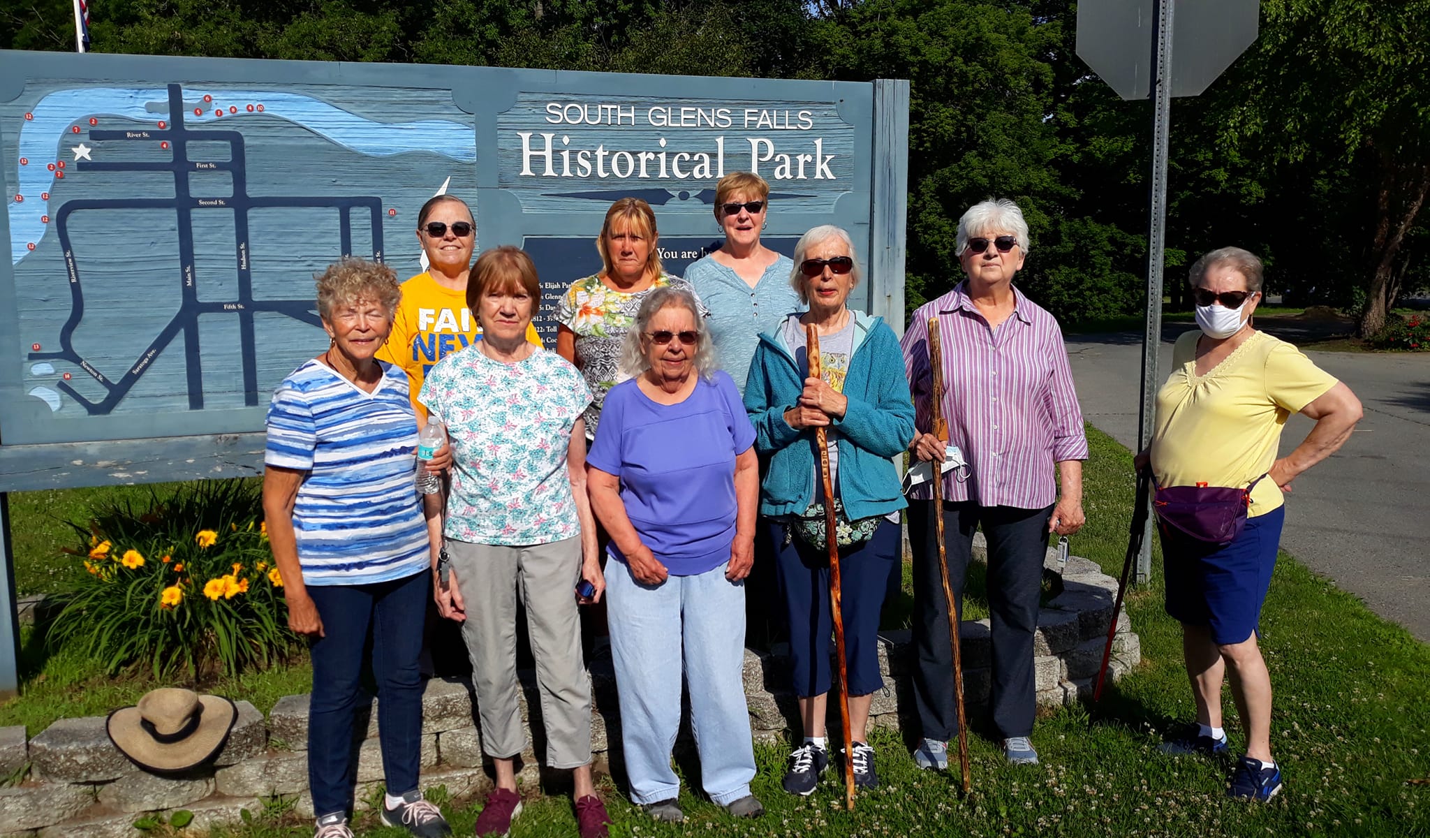 Nine ladies of Walking group stand in front of sign